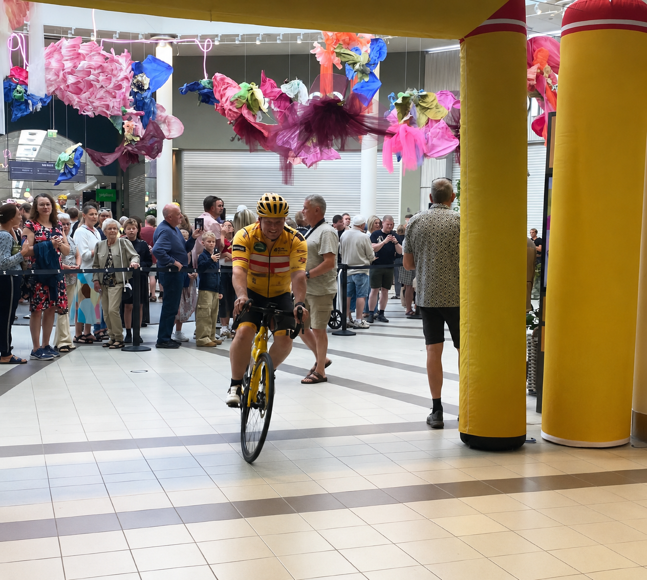 En Team Rynkeby deltager cykler gennem portalen i Kolding Storcenter og mod Paris